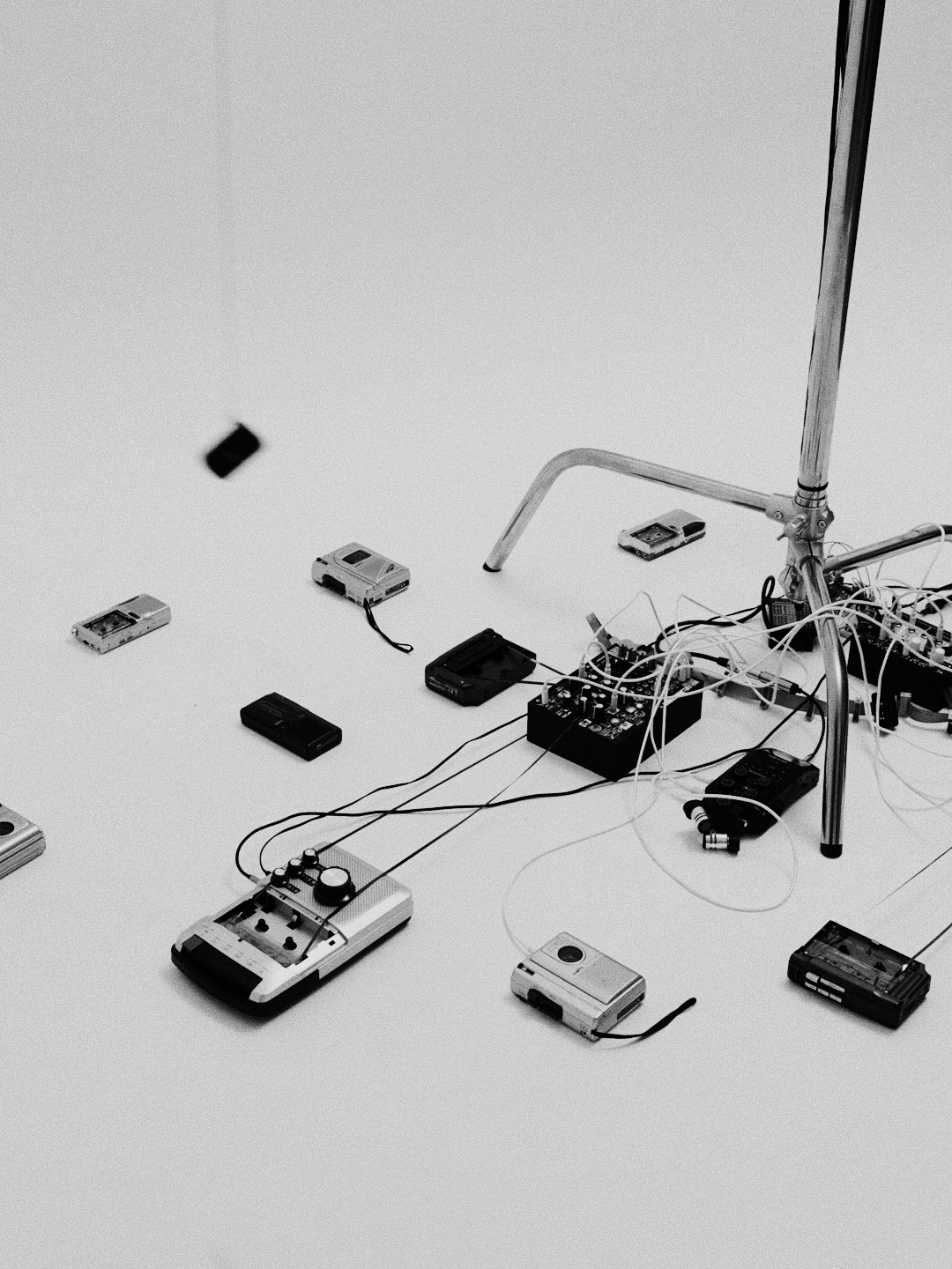 Cassette players scattered on the floor around the microphone stand and audio electronics.